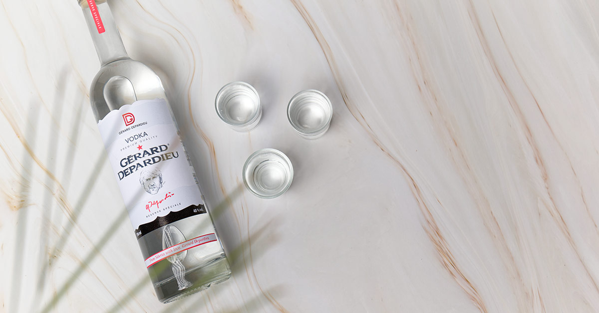 Vodka ou whisky. Photo de la bouteille de vodka Gérard Depardieu et de verres à shooter